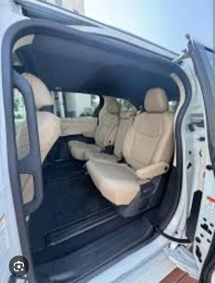 Minivan passenger cabin Passenger seating visible through the open sliding door of a minivan.